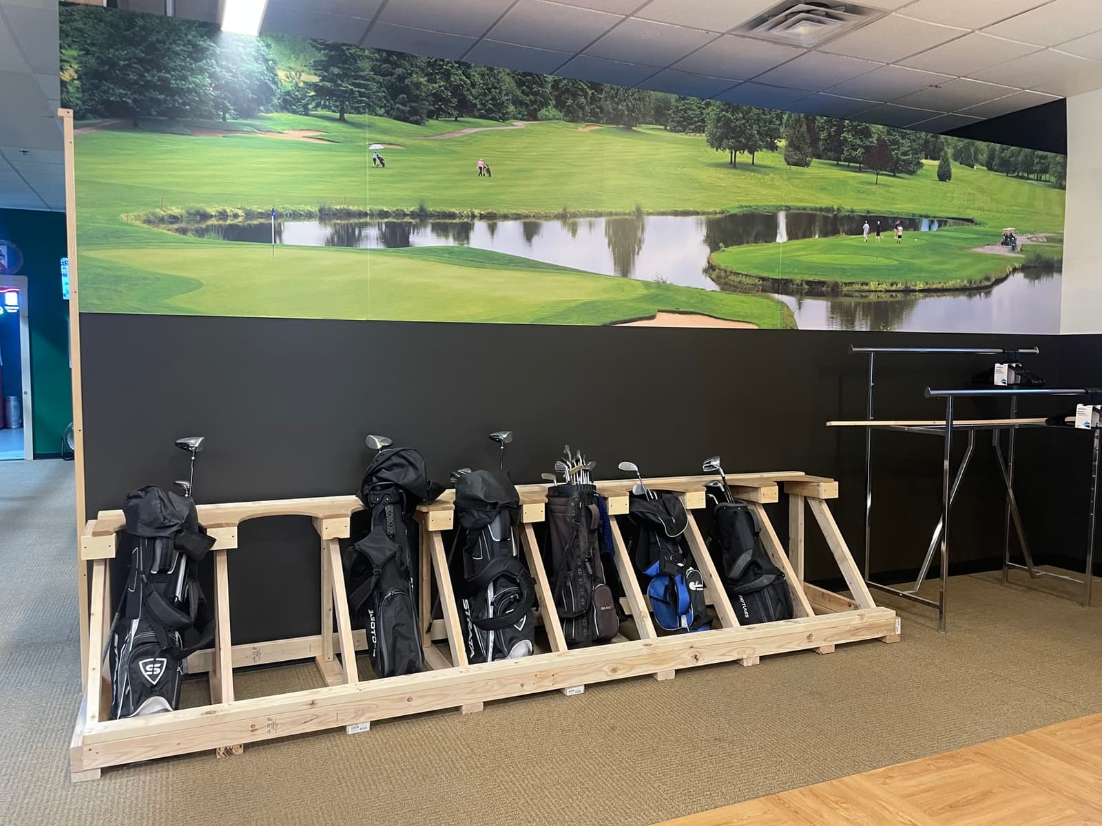 Golf bags in front of the golf mural at Swing Sportsplex